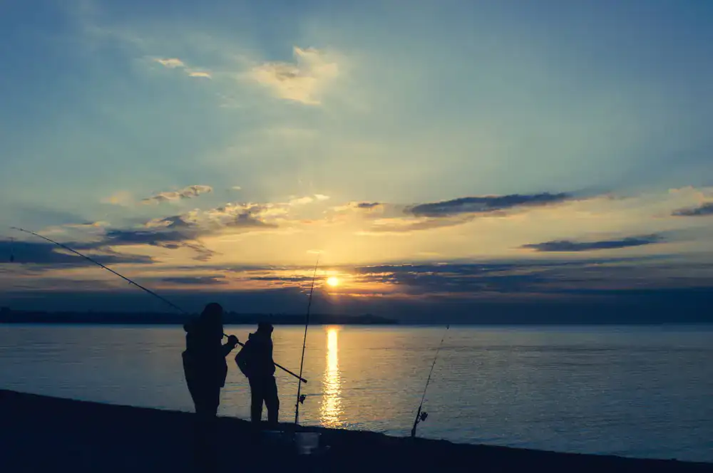 Panoramic view of an angler casting a line at sunrise